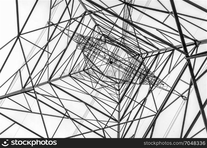tall power line pylon silhouette against sky looking up