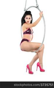 Tall slender woman suspended from an aerial hoop