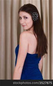 Tall, slender young brunette in a short blue dress