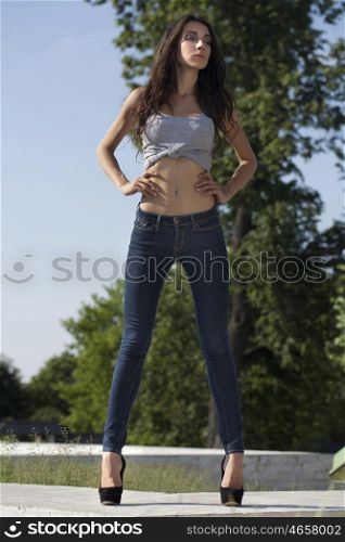 Tall, slim model in blue jeans on the background of blue sky