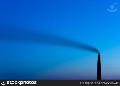 tall smokestack belches smoke into evening sky, copy space