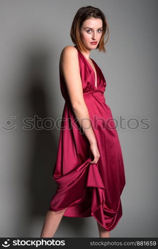 Tall young redhead in a long red dress