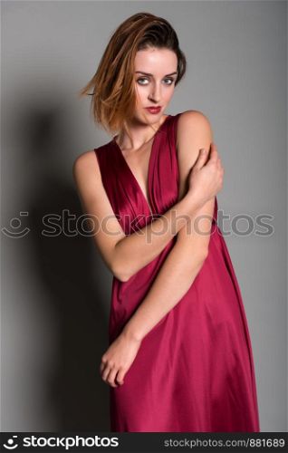 Tall young redhead in a long red dress