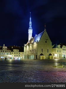 Tallinn town hall at night in Raekoya square showing the floodlit spire and tower of the hall