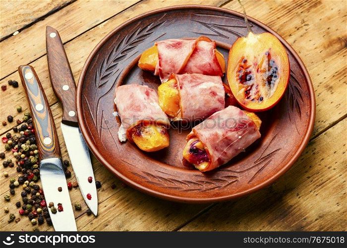 Tamarillo pieces wrapped and baked with ham and bacon. Ham rolls stuffed with tamarillo