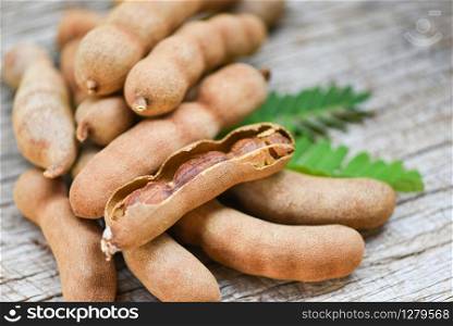 Tamarind and leaves tropical fruit / Sweet tamarind on wooden background
