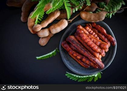 Tamarind peel in plate tropical fruits summer, Tamarind sweet for food fruit ripe tamarinds on plate and white background - top view 