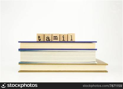 tamil word on wood stamps stack on books, academic and language concept
