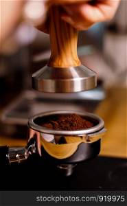 Tamped espresso with an olive wood tamper