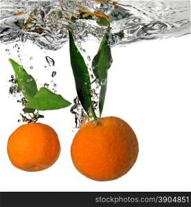 tangerine dropped into water with bubbles on white
