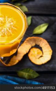 tangerine juice in glass on dark blue wooden background