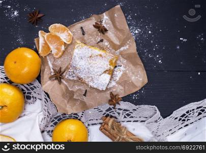 tangerine pie sprinkled with powdered sugar and fresh tangerines, top view