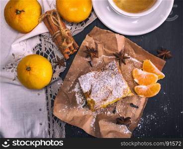 tangerine pie sprinkled with powdered sugar, fresh tangerines, next to a round cup with coffee, top view