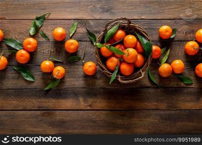 Tangerines, fresh mandarin oranges, clementines with leaves on wooden background. Top view, copy space