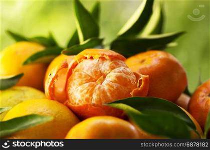tangerines, peeled tangerine on a green background