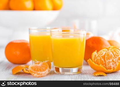 Tangerines, peeled tangerines and tangerine juice in glass. Mandarine juice.