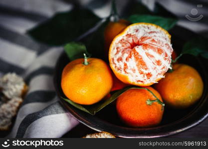 Tangerines with leaves on rustic wooden background