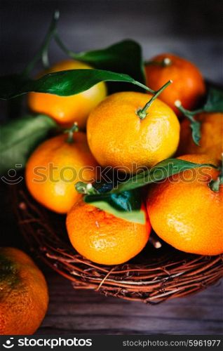 Tangerines with leaves on rustic wooden background