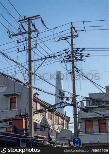 Tangle of electric and telephone wires on pole in front of building. Electric and telephone cabling on pole in Shanghai China