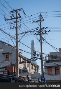 Tangle of electric and telephone wires on pole in front of building. Electric and telephone cabling on pole in Shanghai China