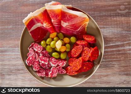 Tapas of Spain with ham olives sausage and chorizo on wooden background