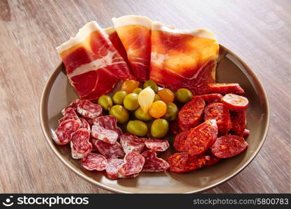 Tapas of Spain with ham olives sausage and chorizo on wooden background