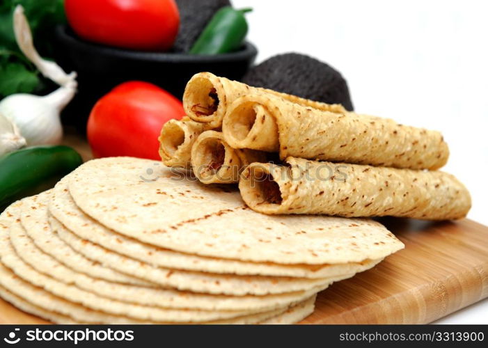 Taquito Closeup. Taquitos with other natural ingredients including homemade tortillas, avocados, tomatoes, small sweet onions and jalapeno chilies