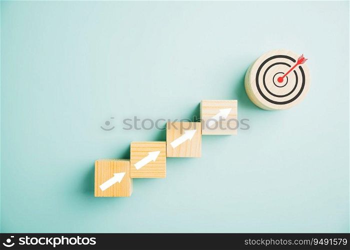 Target icon integrated into wooden blocks with rise up arrows, portraying business growth. Bar graph chart steps on a blue background symbolize profit, investment, and economic improvement concepts.