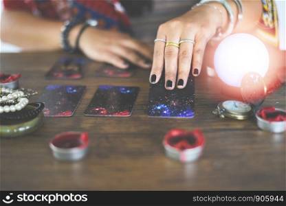 Tarot cards reading divination Psychic readings and clairvoyance concept / Crystal ball fortune teller hands