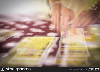 Tarot cards reading divination / Psychic readings and clairvoyance fortune teller hands concept , with effect filter blur selective focus