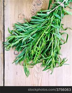 Tarragon fresh green tied with twine on the background of wooden boards