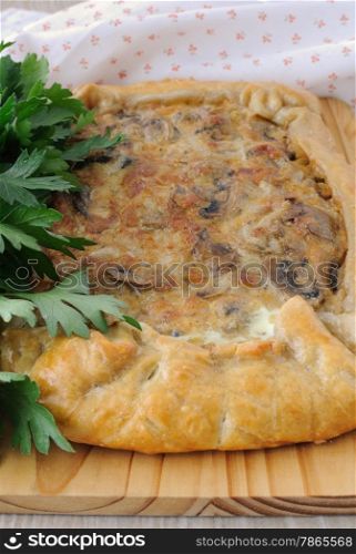 Tart with mushrooms in a creamy sauce with herbs close up