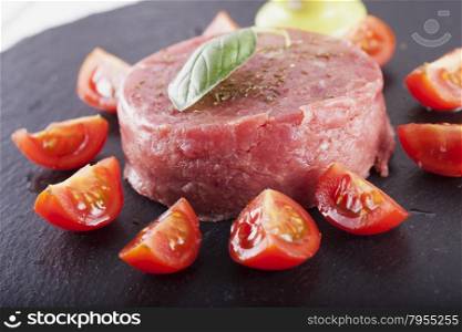 Tartare raw meat with tomatoes and egg cream over black stone plate, horizontal image