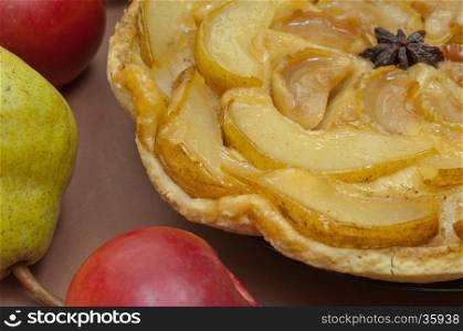 Tarte Tatin apple and pear tart pie on light brown background with copy space