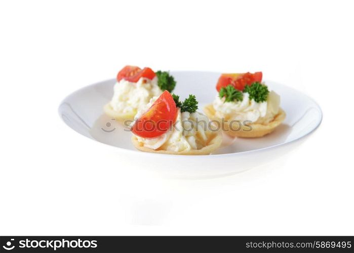 tartlet with cream, tomato and dill on dish