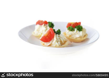 tartlet with cream, tomato and dill on dish