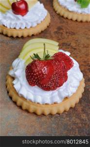 Tartlets filled whipped cream and apples with raspberries