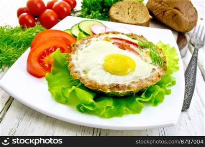 Tartlets meat with egg and tomato in the plate on lettuce, bread and dill on the background wooden boards