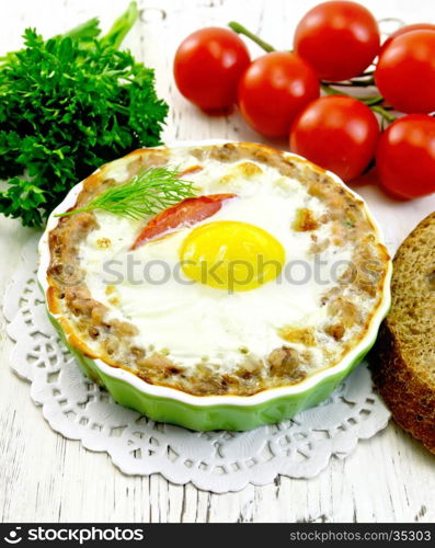 Tartlets meat with eggs and tomatoes in the form, bread, parsley and dill on a wooden boards background
