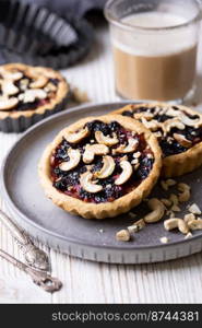 tartlets with apple jam and blueberry confiture with cashew nuts 