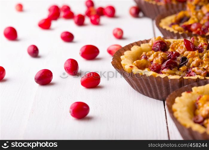 tartlets with cranberries and nuts on a white background