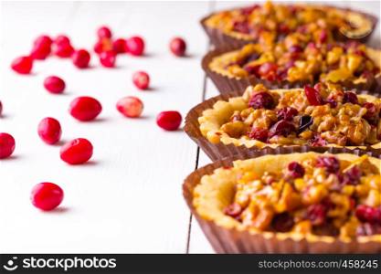 tartlets with cranberries and nuts on a white background