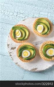 Tartlets with cream cheese, avocado and quail eggs