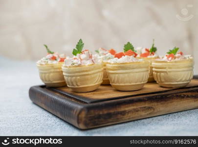 tartlets with Olivier salad with crab sticks and filling on a festive table