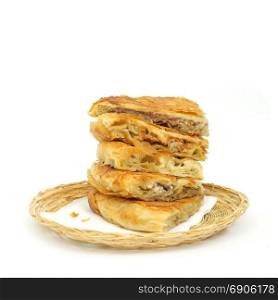 taste variety Stack of crispy Burek or pies on a paper serviette in a wicker or bread basket over white background