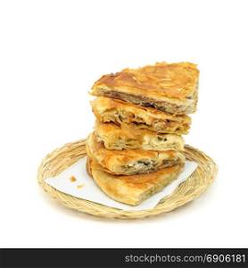 taste variety Stack of crispy Burek or pies on a paper serviette in a wicker or bread basket over white background