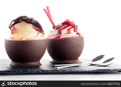 Tasteful strawberry and chocolate pastry mousse on black slate background.