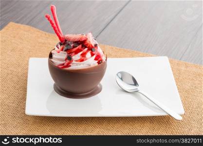Tasteful strawberry and chocolate pastry mousse on white plate background.
