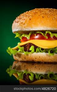 Tasty and appetizing hamburger on a darkly green background