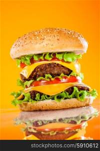 Tasty and appetizing hamburger on a yellow background